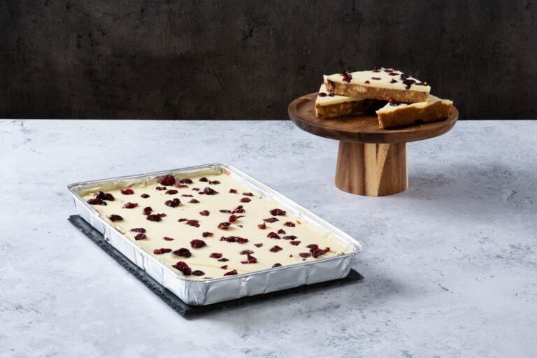 Cranberry blondie traybake with white chocolate topping.