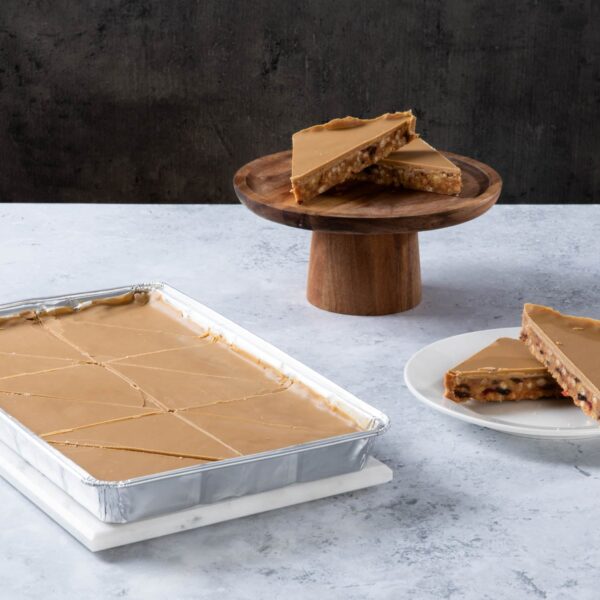 Caramel shortbread slices with caramel topping on a wooden stand and plate.