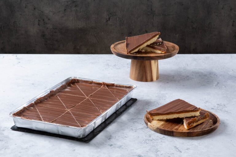 Chocolate caramel shortbread traybake with sliced pieces.