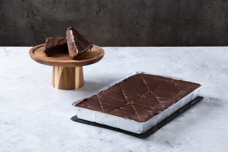 Chocolate fudge cake slices with chocolate frosting in a baking tray.
