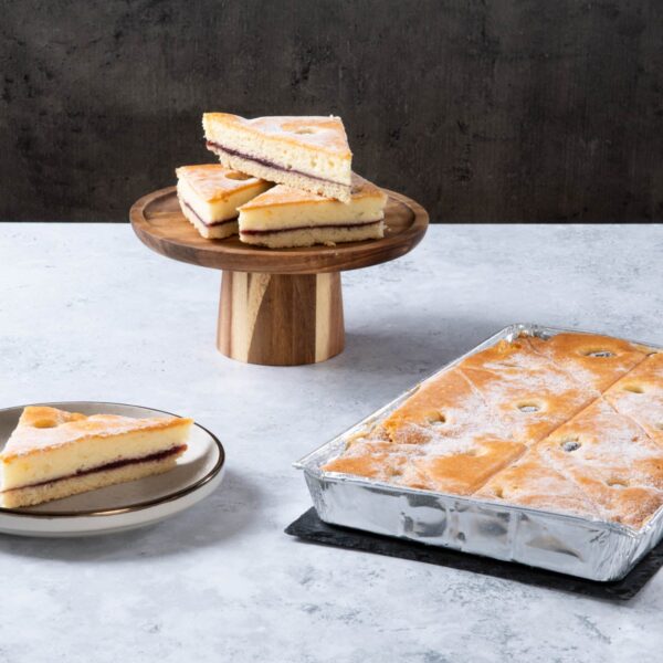 a square sponge traybake with a dark berry filling