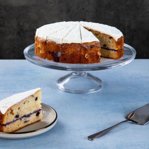 a blueberry cake with white frosting and a slice on a plate