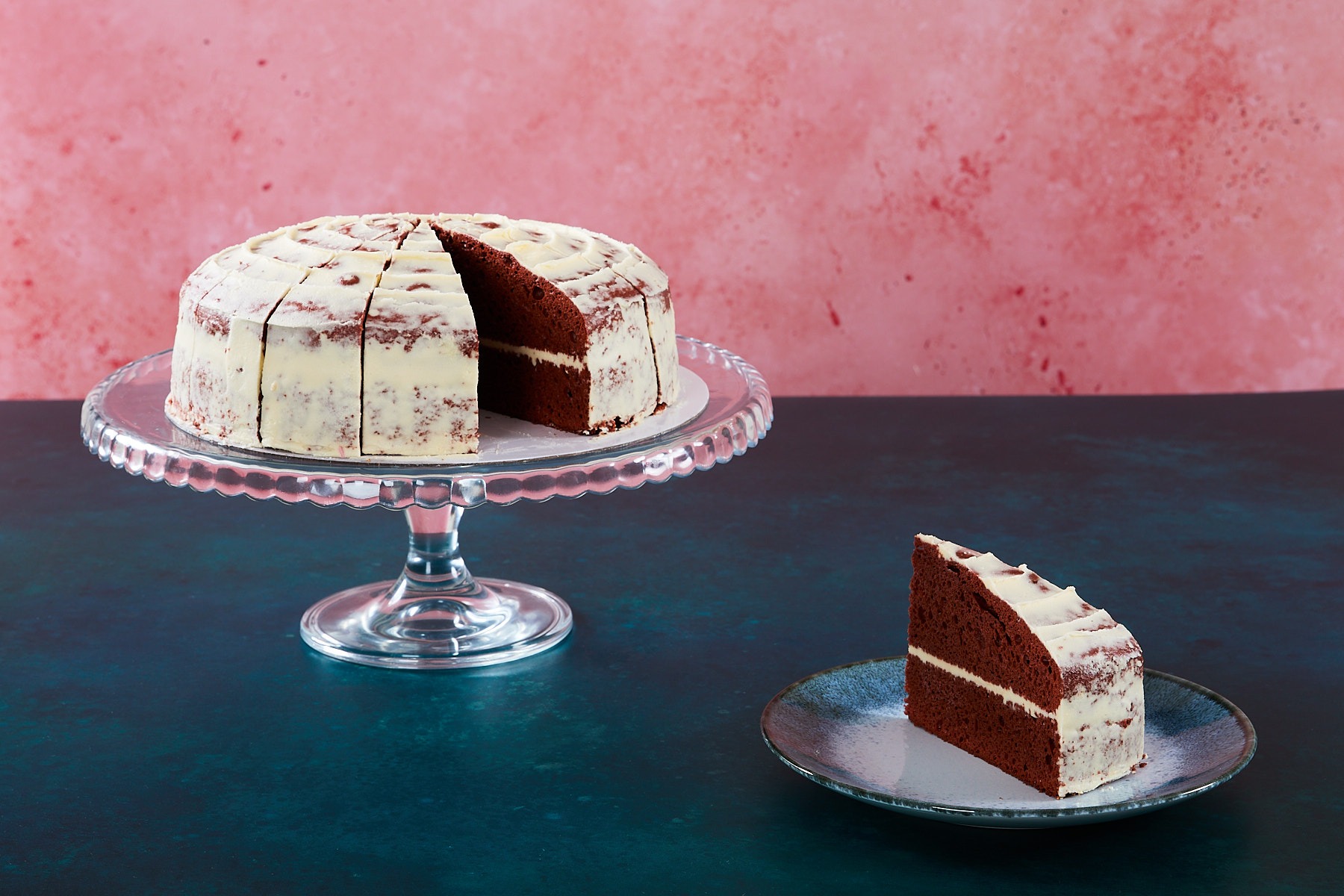 Red velvet cake with cream cheese frosting and red velvet crumbs.