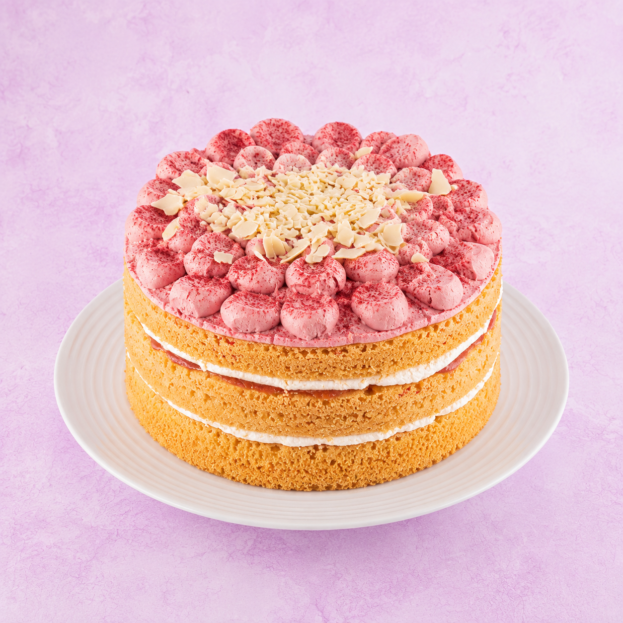 a round cake with white frosting and fruit decoration